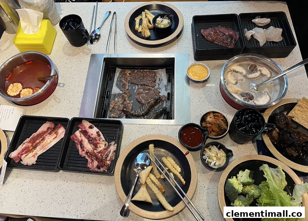 A vibrant table spread featuring Korean BBQ and hotpot with various ingredients and side dishes.