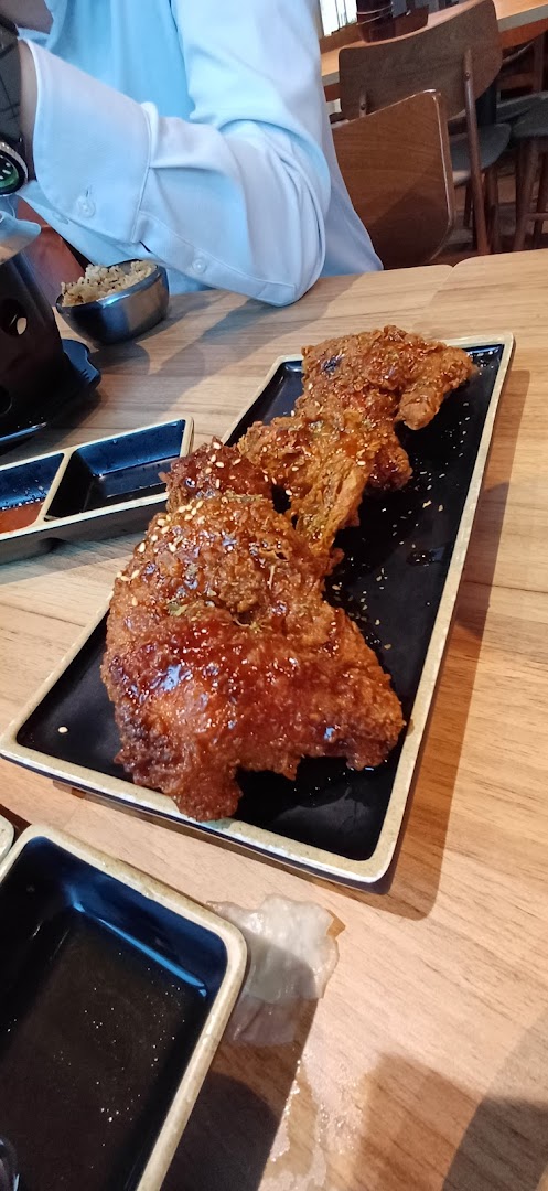 A plate of crispy, glazed fried chicken served on a black rectangular dish at Seoul Garden.