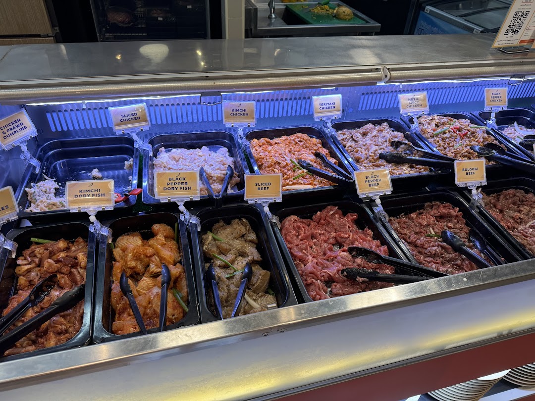A vibrant display of various marinated meats and seafood in a buffet-style counter at Seoul Garden.