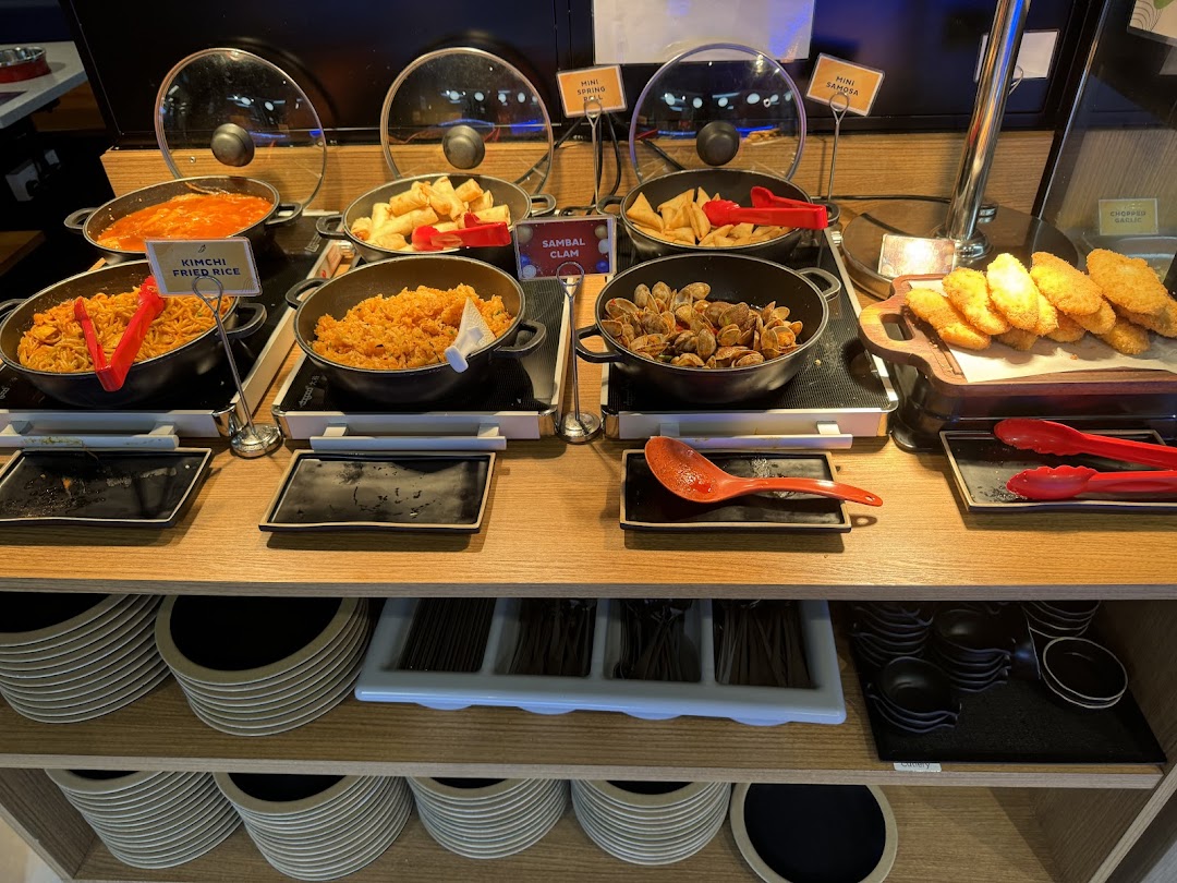 A vibrant buffet spread at Seoul Garden featuring hot dishes like Kimchi Fried Rice, Sambal Clam, and Mini Samosa.
