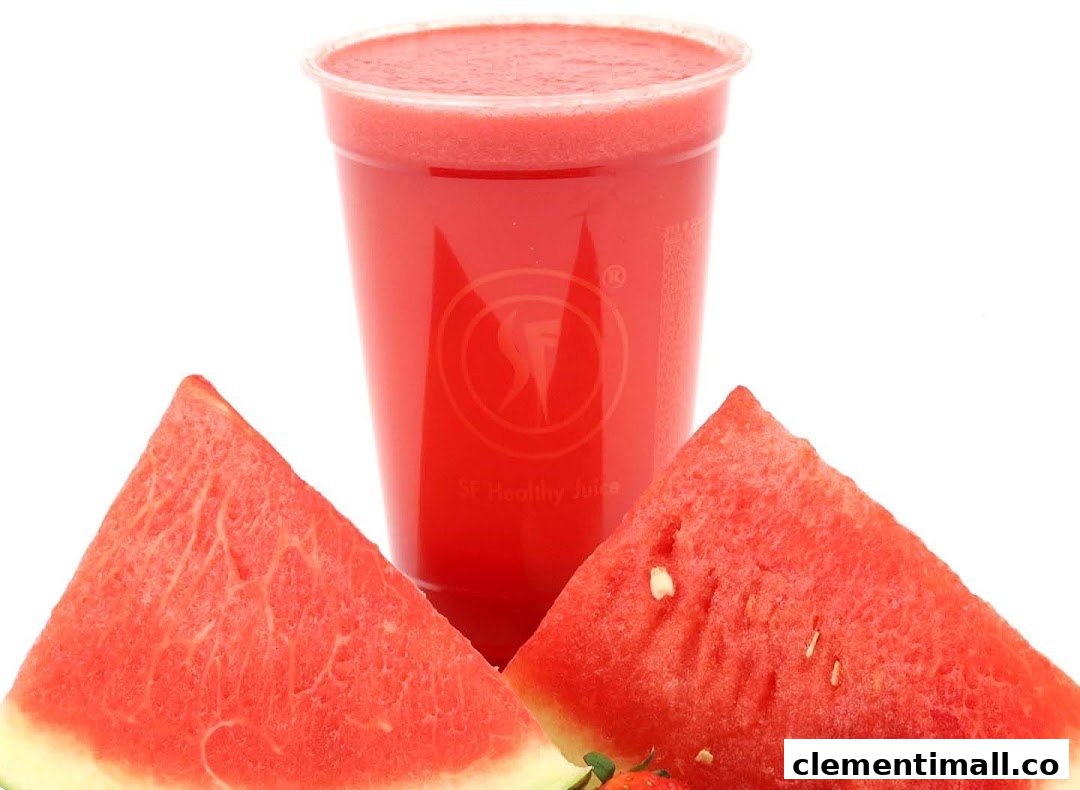 A vibrant red watermelon juice in a clear cup, flanked by fresh watermelon slices.