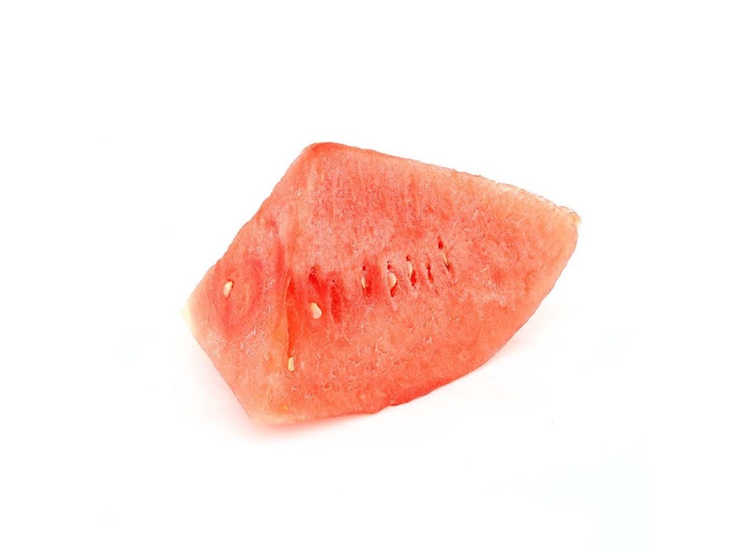 A vibrant red slice of watermelon with visible seeds on a white background.
