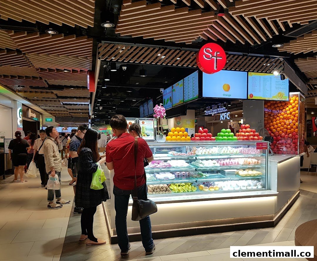 A vibrant fruit and juice stall in a mall, showcasing fresh produce and prepared fruit.