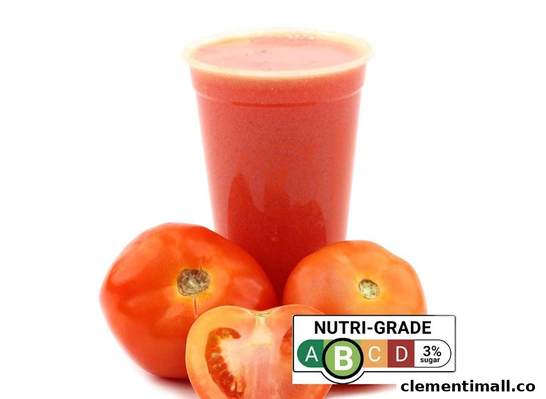 A vibrant tomato juice in a cup, surrounded by fresh tomatoes, with a Nutri-Grade B label.