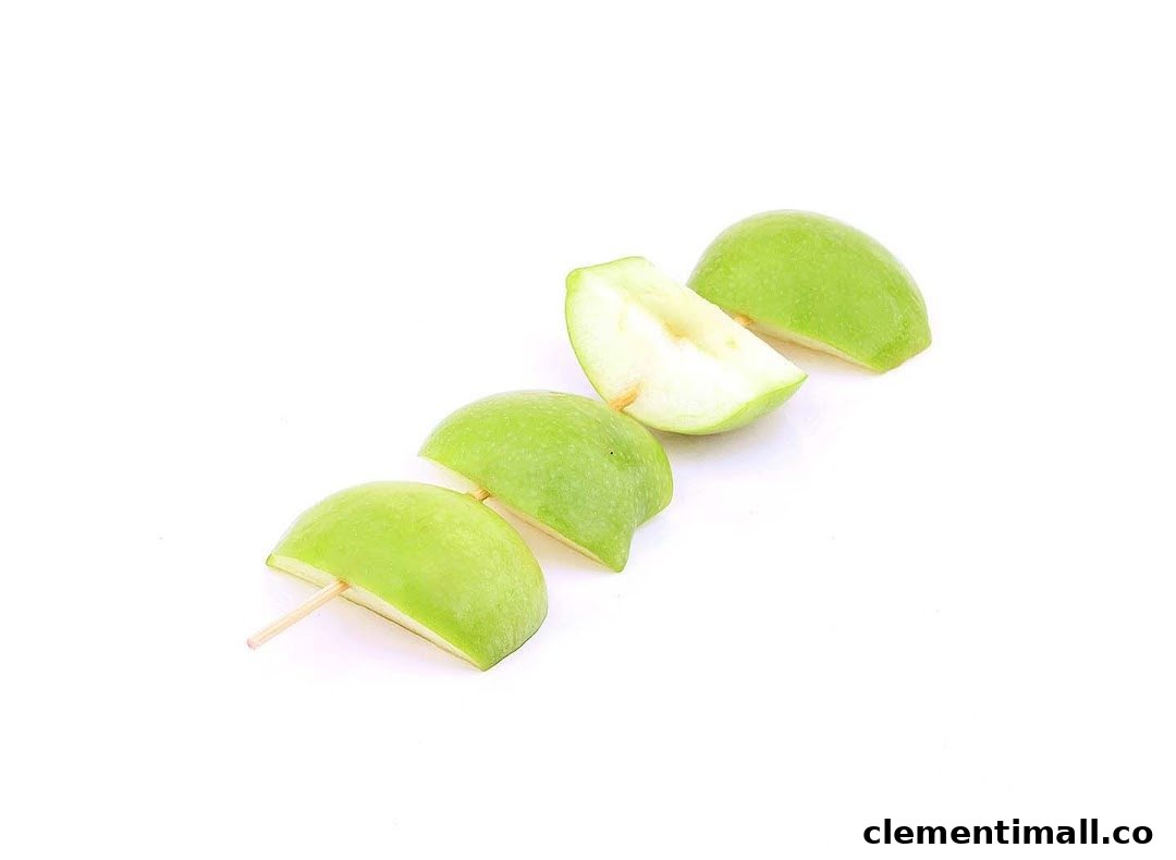 Fresh green apple slices on a skewer, ready for a refreshing snack.