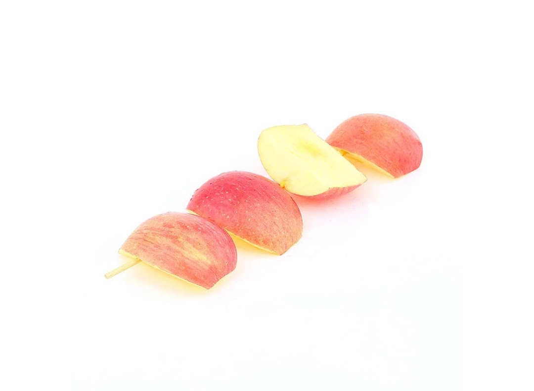 Red apple slices on a stick, presented against a clean white background.