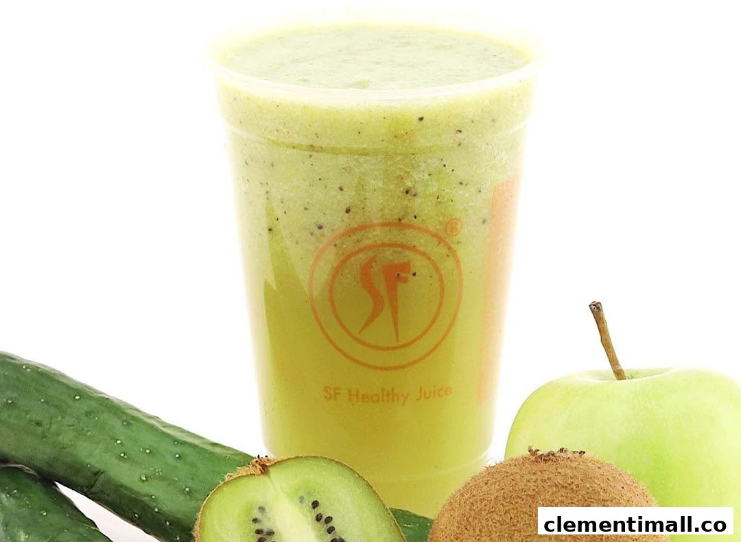 A vibrant green smoothie in a clear cup, surrounded by fresh kiwi, cucumber, and a green apple.