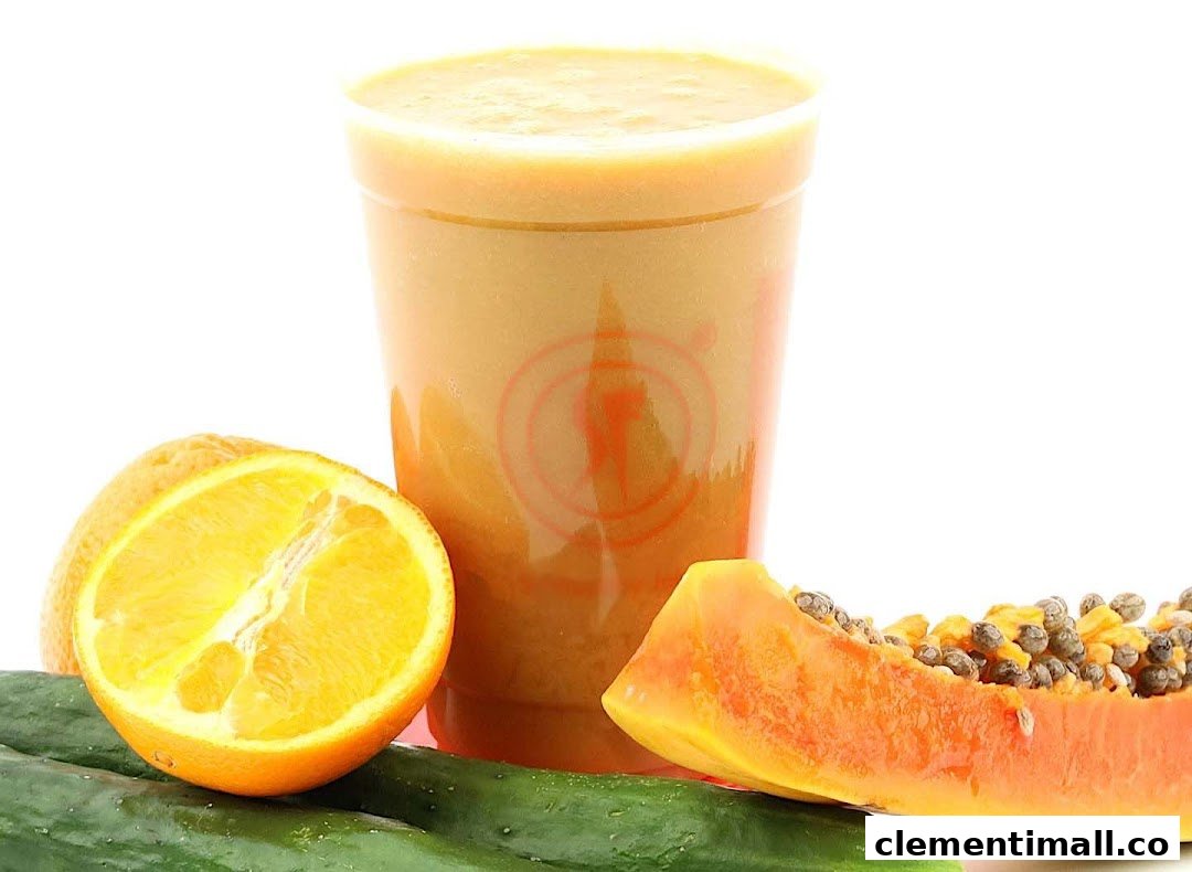 A refreshing fruit smoothie in a cup, surrounded by fresh orange, papaya, and cucumber.