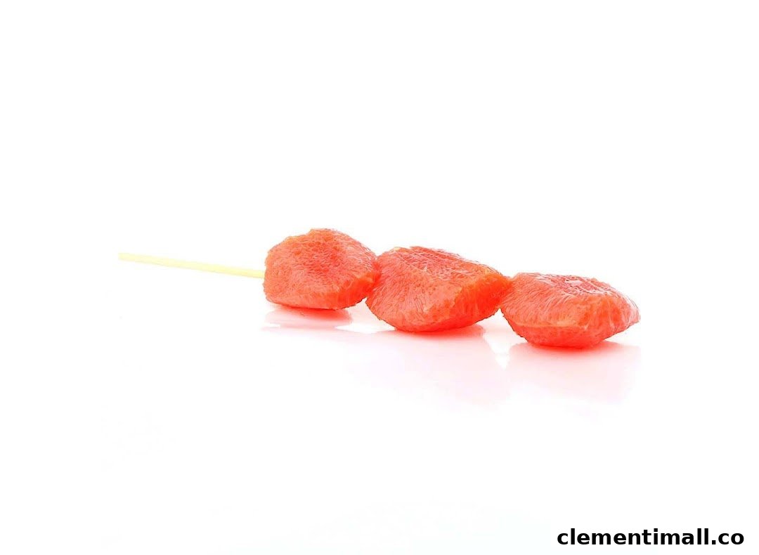 Three vibrant pink fruit segments on a skewer, presented on a clean white background.