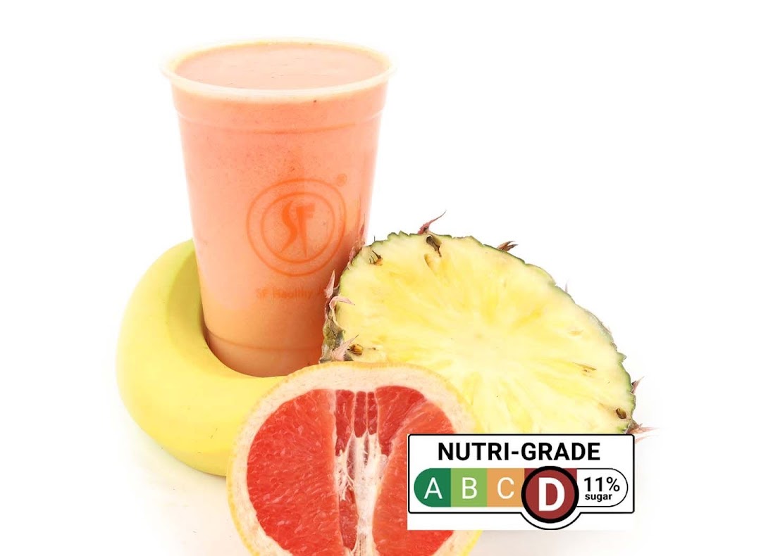 A vibrant fruit smoothie with fresh banana, pineapple, and grapefruit, featuring a Nutri-Grade label.