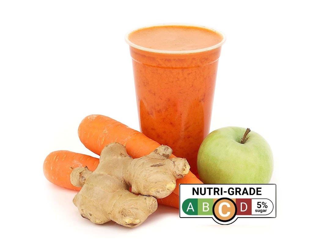 A vibrant orange juice with carrots, ginger, and an apple, featuring a Nutri-Grade C label.