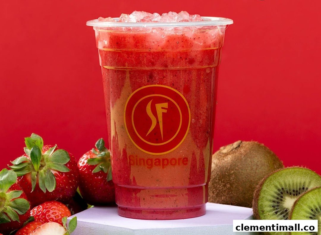 A vibrant strawberry smoothie with ice, surrounded by fresh strawberries and kiwi fruit.