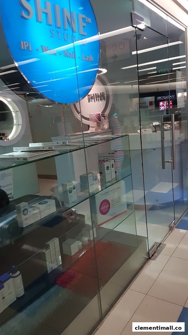 The glass storefront of SHINE Studio, featuring its blue circular logo and services like IPL, Wax, Nail, and Lash.