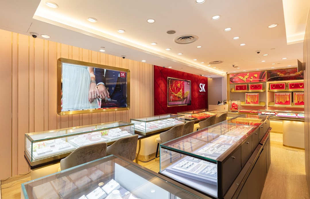Interior view of SK Jewellery store showcasing display cases filled with various jewelry and digital screens.
