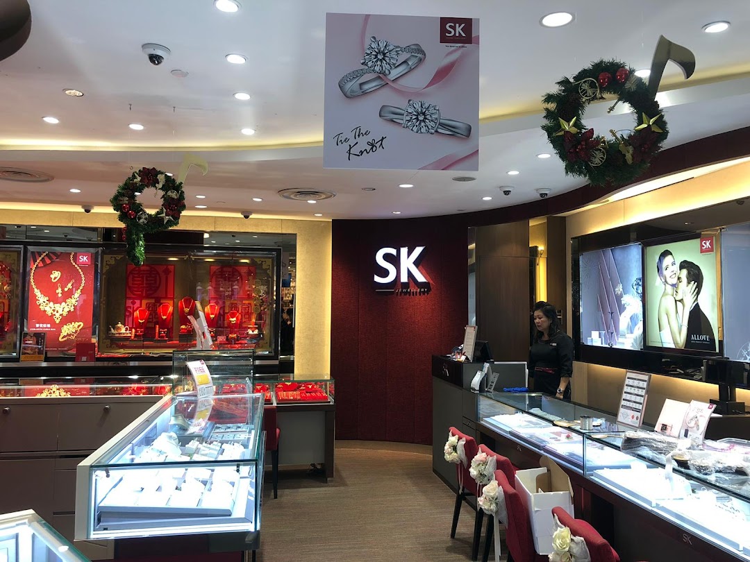 Interior view of SK Jewellery shop showcasing display cases, a service counter, and festive decorations.
