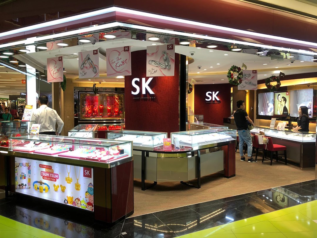 Interior view of SK Jewellery showcasing display cases filled with jewellery, staff, and customers.