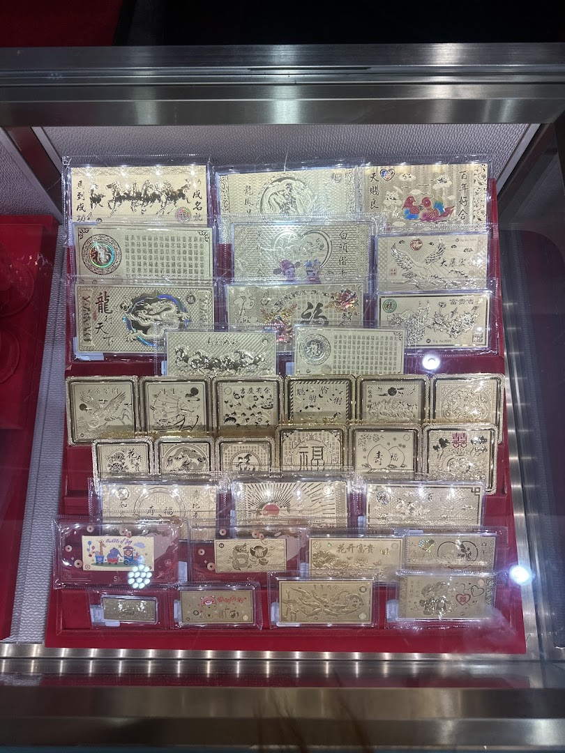 A display case showcasing numerous gold-colored plaques and bars with intricate designs and Chinese characters.