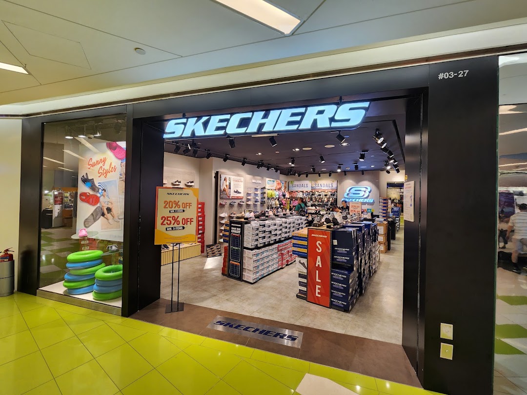 The brightly lit entrance of a Skechers shoe store, showcasing its interior and a prominent sale sign.