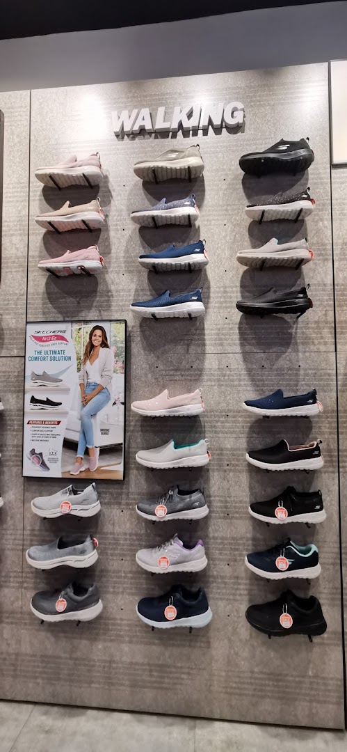 A wall display inside Skechers showcasing various walking shoes for men and women.