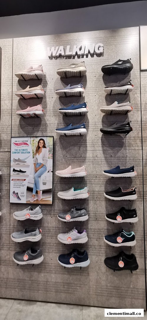 A wall display inside Skechers showcasing various walking shoes for men and women.