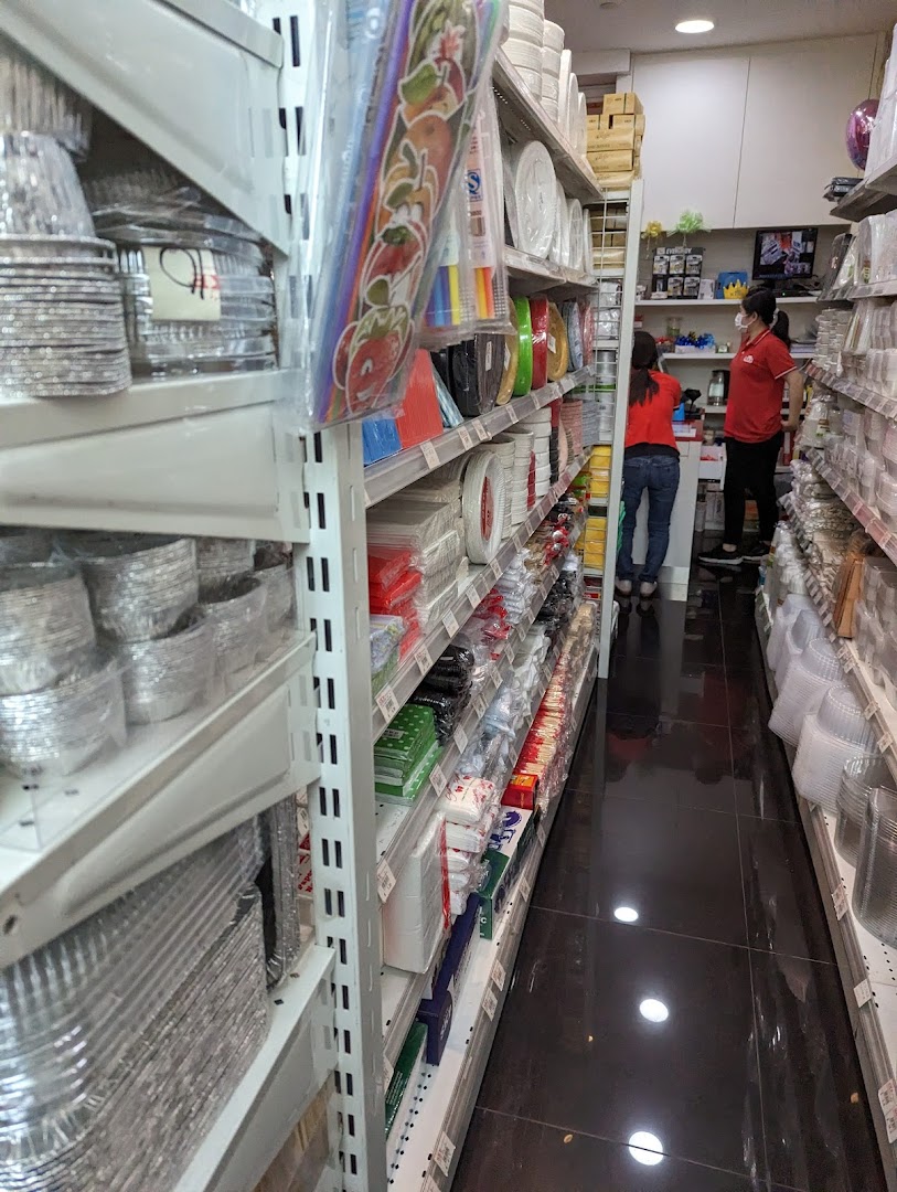 An aisle in SKP Clementi Mall, showcasing shelves stocked with baking and party supplies, with staff present.