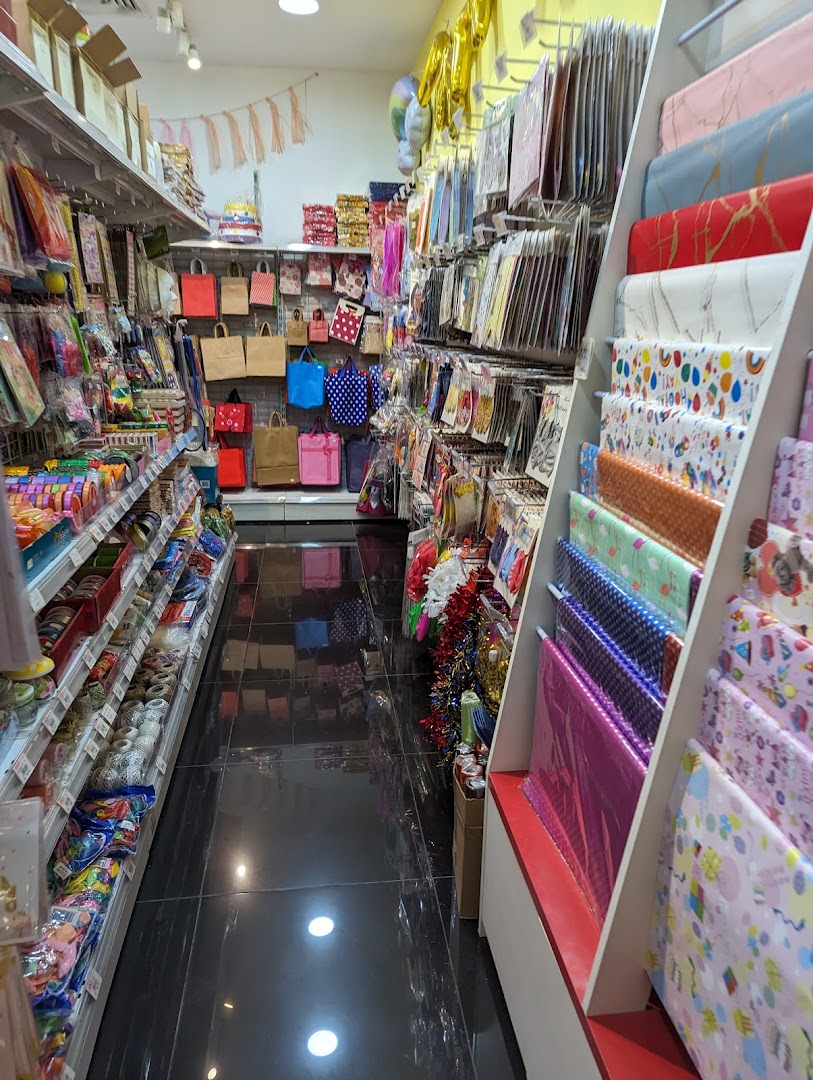 An aisle view inside a party supply and gift shop, showcasing wrapping paper, gift bags, and decorations.