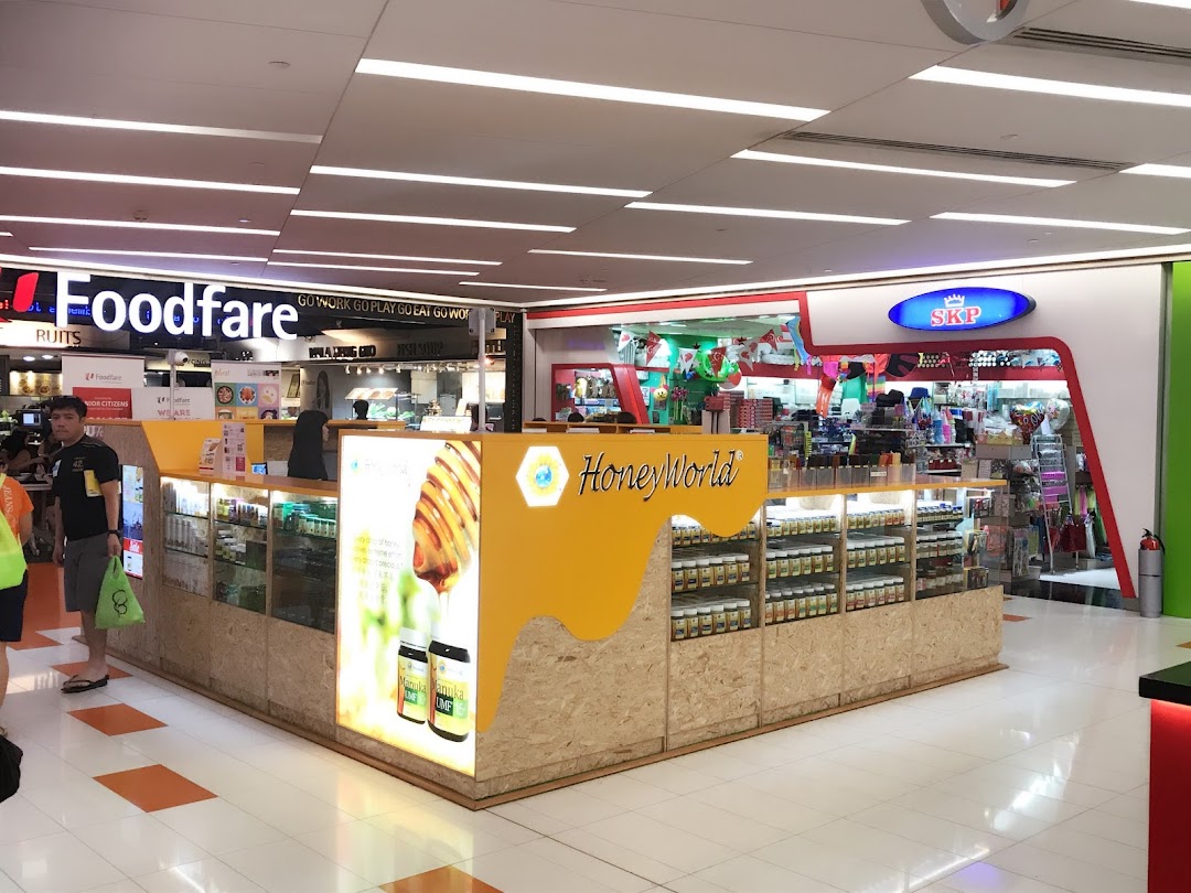 A mall interior featuring a HoneyWorld kiosk, SKP shop entrance, and Foodfare food court.