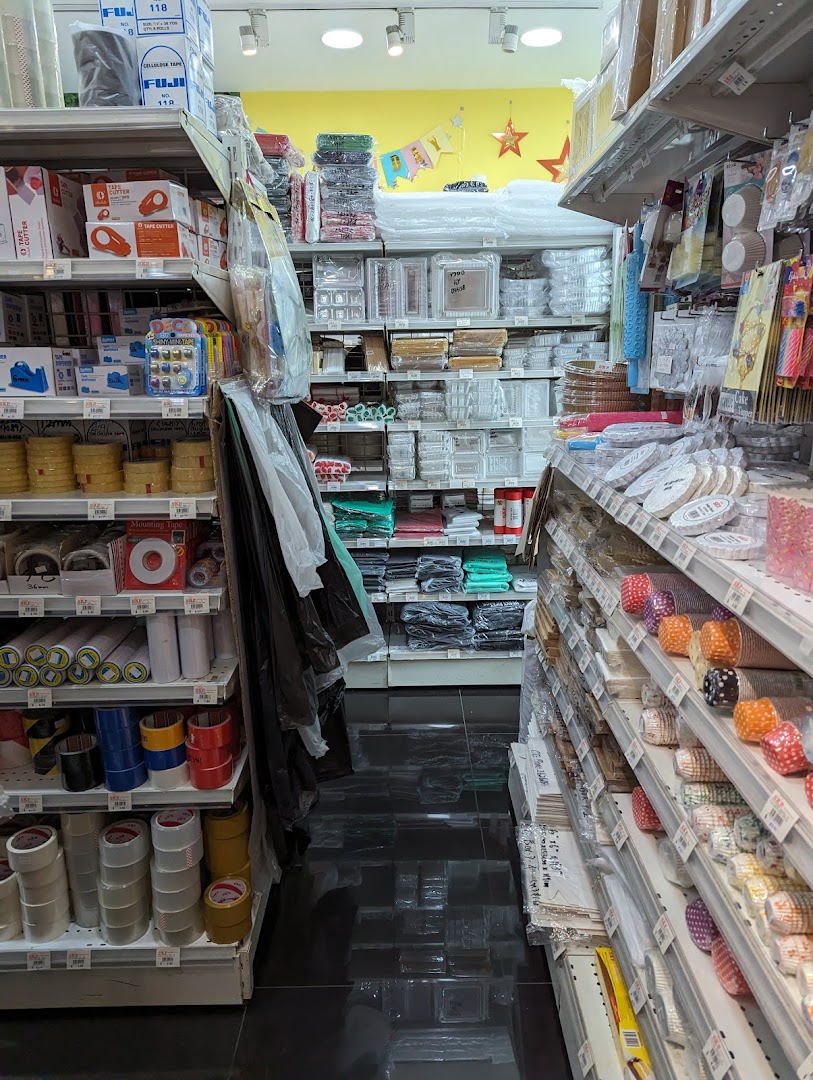Aisle view inside SKP Clementi Mall, showcasing shelves stocked with various craft, baking, and packaging supplies.