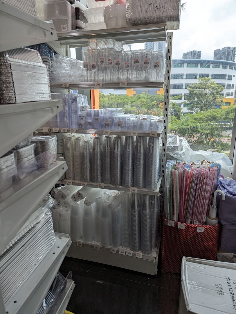 Shelves stocked with various disposable food containers, cups, and party supplies inside a retail store.