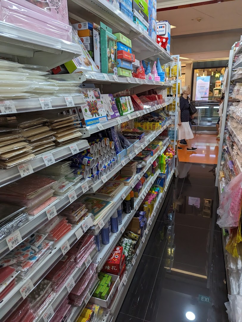An aisle view inside SKP Clementi Mall, showcasing shelves filled with a wide array of party supplies, craft items, and stationery.