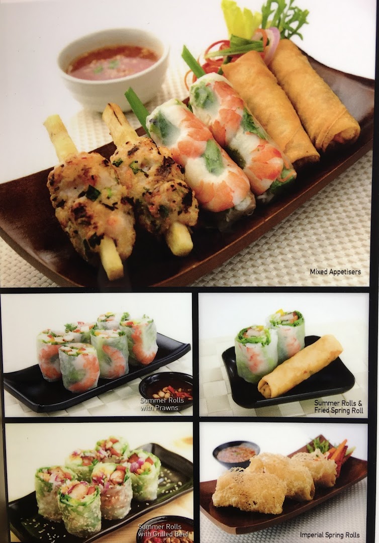 A vibrant display of Vietnamese appetizers including summer rolls, spring rolls, and skewers.