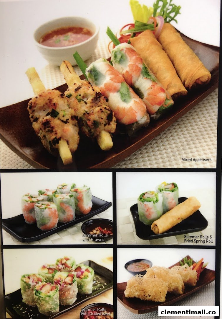 A vibrant display of Vietnamese appetizers including summer rolls, spring rolls, and skewers.