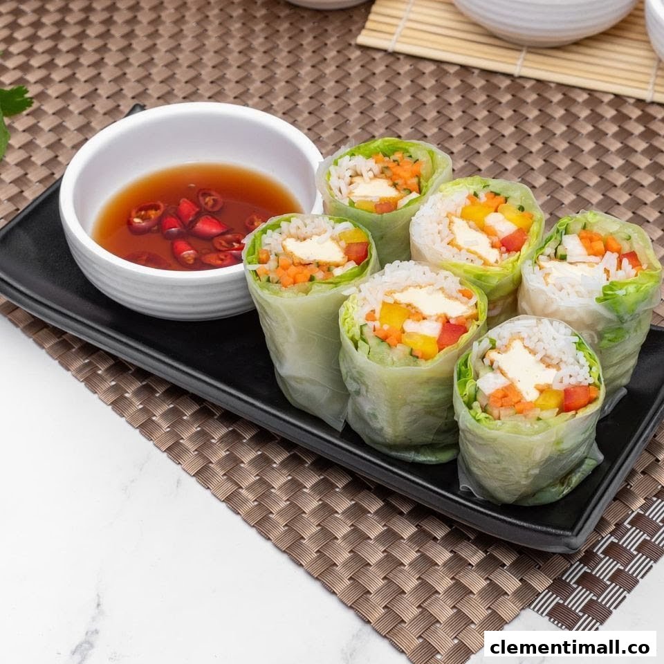 A plate of fresh Vietnamese spring rolls filled with vegetables and tofu, served with a chili dipping sauce.