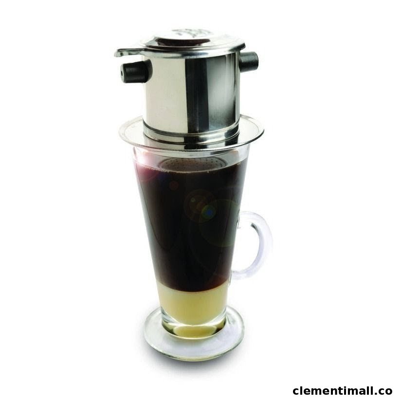 A Vietnamese phin filter brewing coffee into a glass with condensed milk.