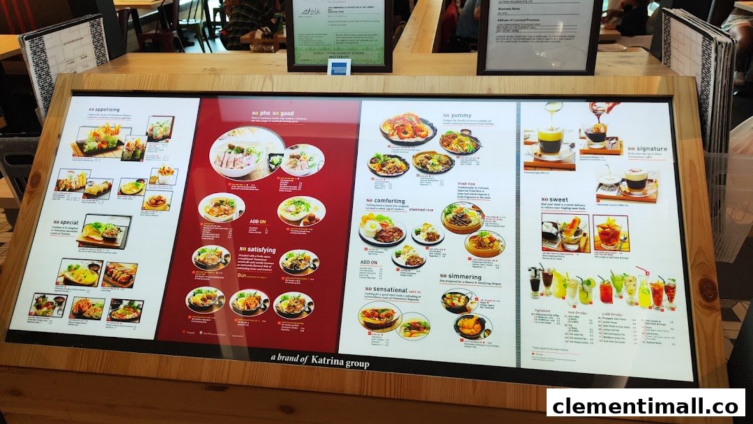 A large, illuminated digital menu board showcasing a variety of Vietnamese dishes and beverages at So Pho.