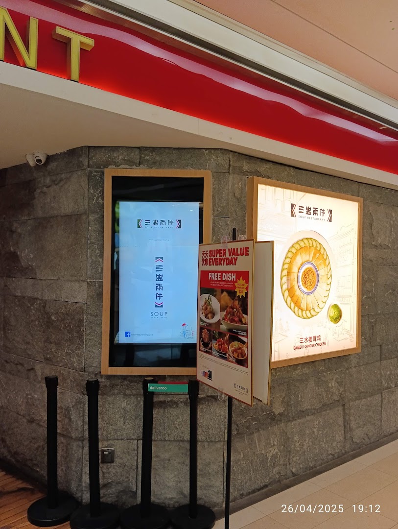Exterior view of Soup Restaurant with promotional displays and digital screen.