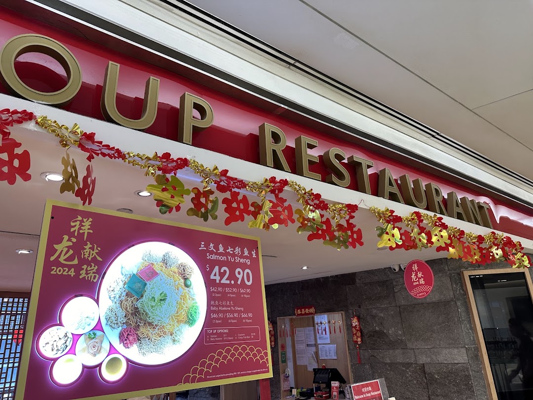 The Soup Restaurant shop front adorned with festive decorations and a Yu Sheng promotional display.