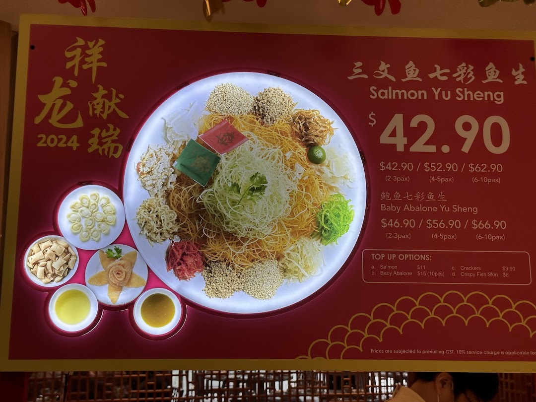 A vibrant menu board showcasing Salmon and Baby Abalone Yu Sheng for Chinese New Year 2024.