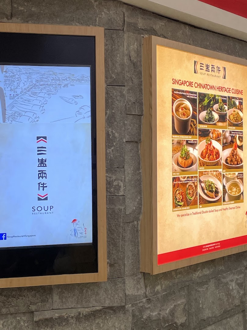 Exterior view of Soup Restaurant featuring a digital display and a backlit menu board.