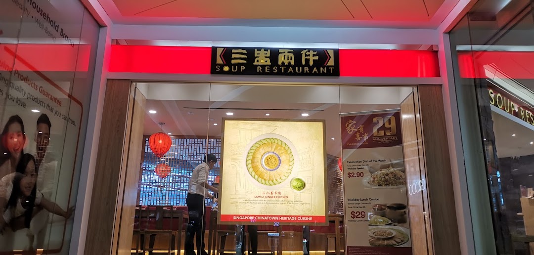The illuminated entrance of Soup Restaurant, showcasing its signboard and promotional displays.