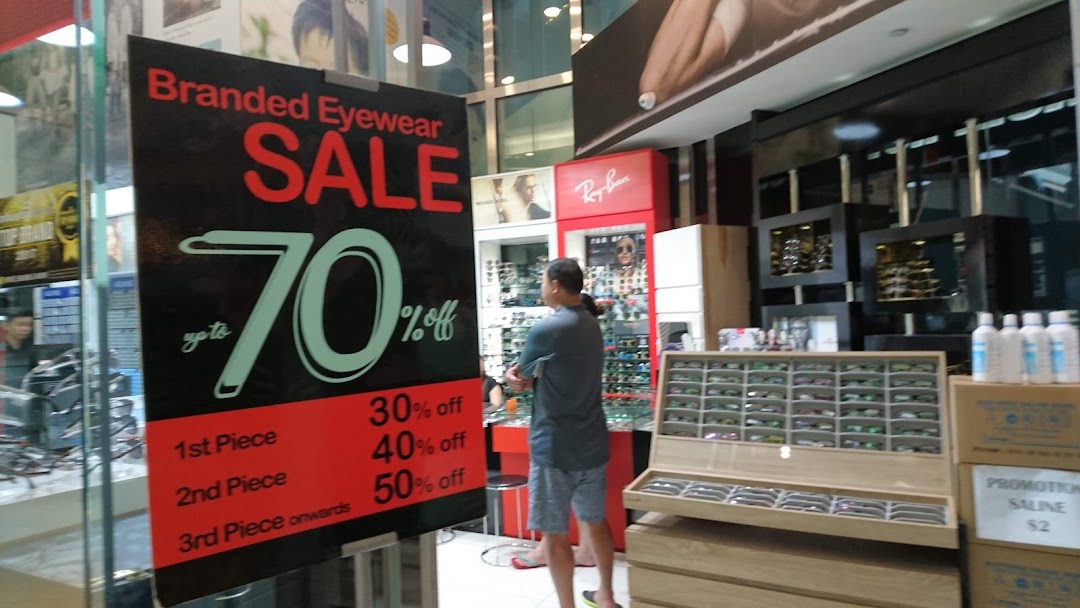 Interior view of Spectacle Hut showcasing eyewear displays, a customer, and a prominent 'Branded Eyewear Sale' sign.