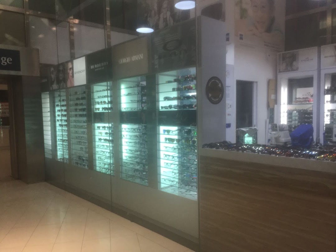 The front of Spectacle Hut, an optical shop, showcasing various eyewear in illuminated display cases.