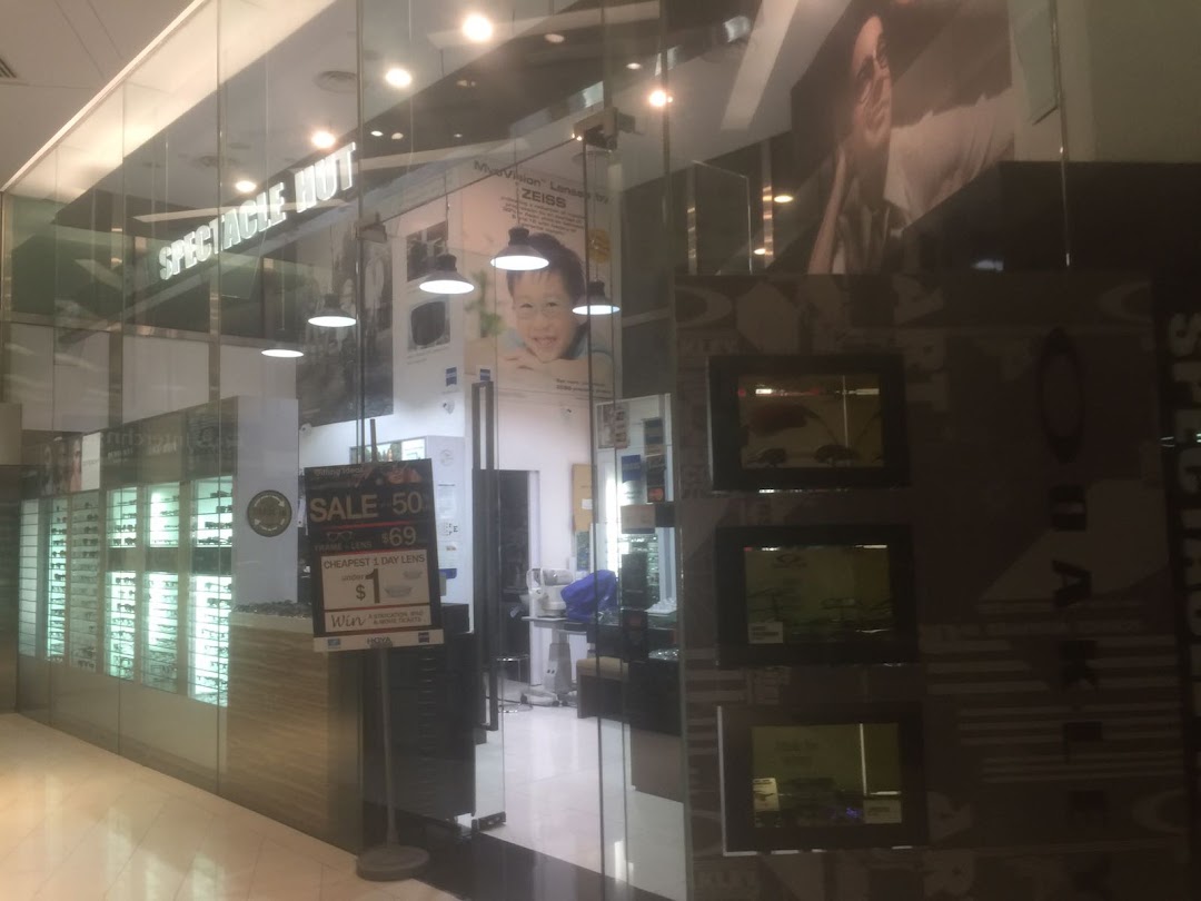 The glass storefront of Spectacle Hut, showcasing eyewear displays and promotional offers on frames and lenses.