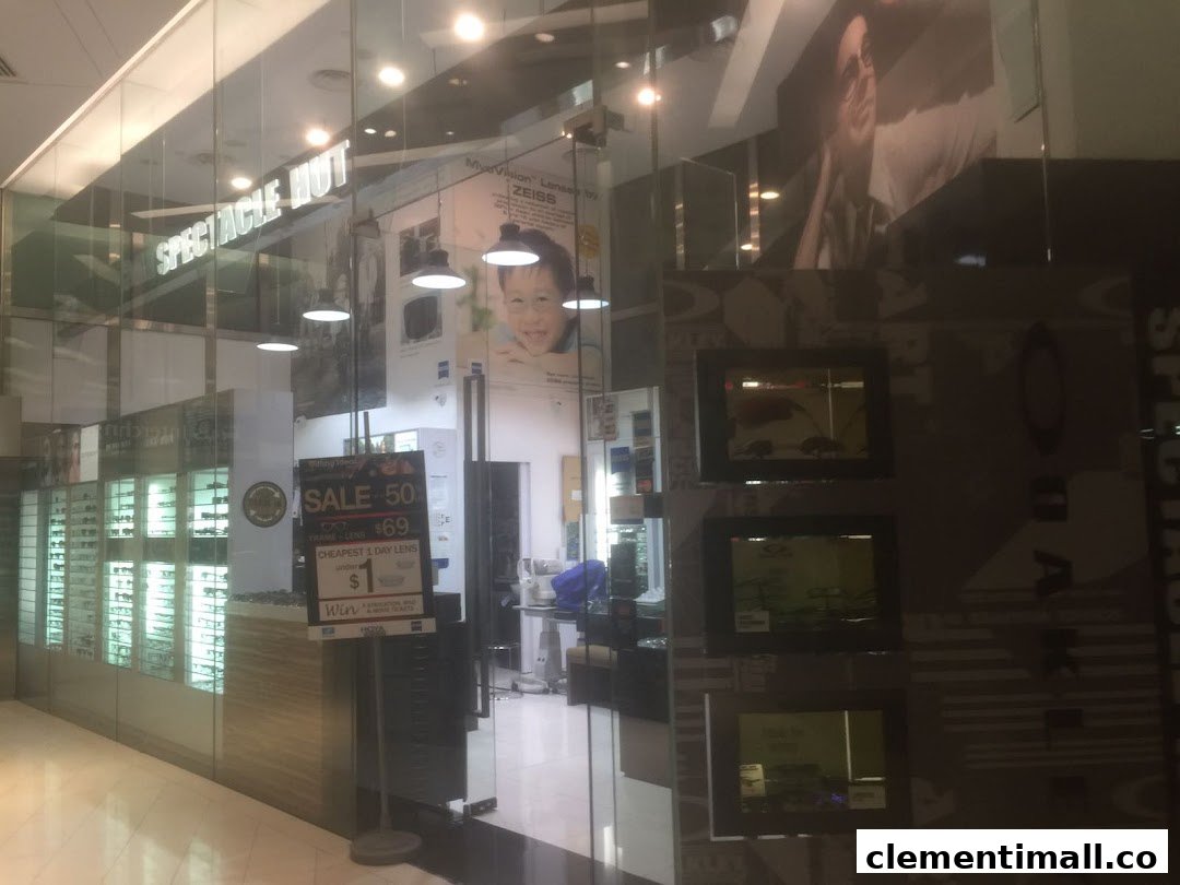 The glass storefront of Spectacle Hut, showcasing eyewear displays and promotional offers on frames and lenses.
