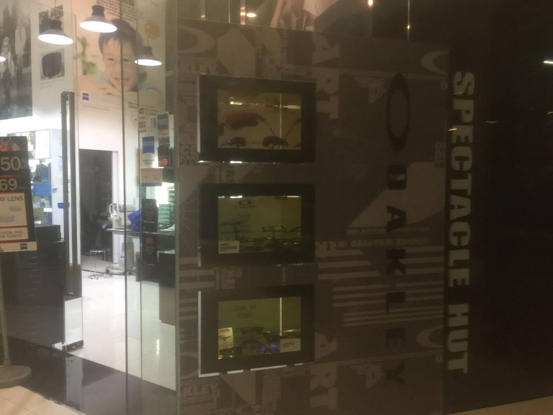 The image shows the entrance of Spectacle Hut, an optical shop, with product displays and branding.