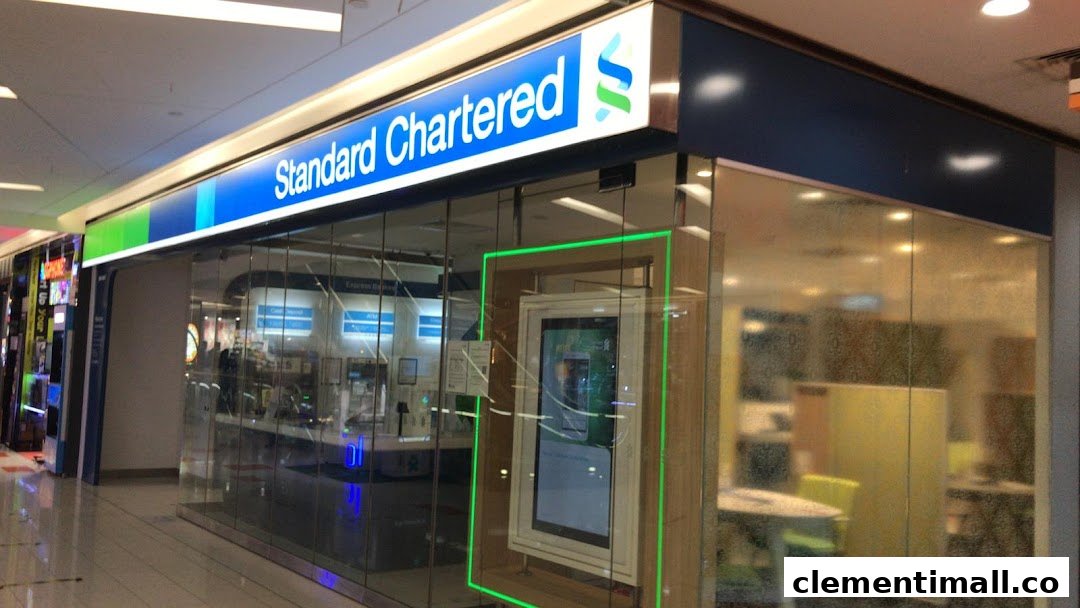 The brightly lit Standard Chartered Bank branch entrance with glass walls and digital displays.