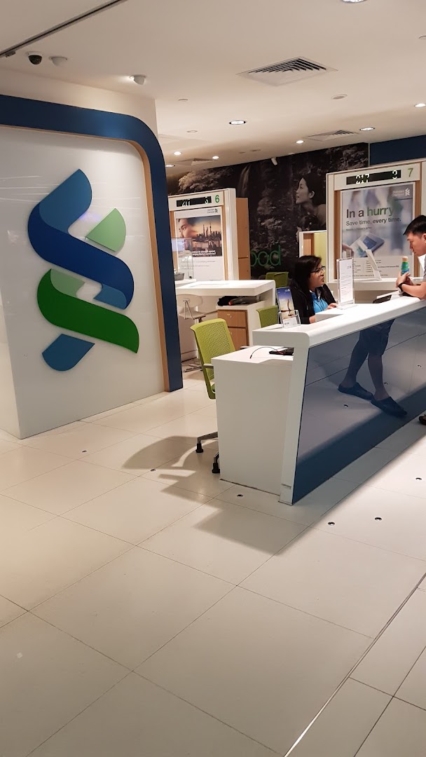 Interior view of Standard Chartered Bank, featuring customer service counters and branding.