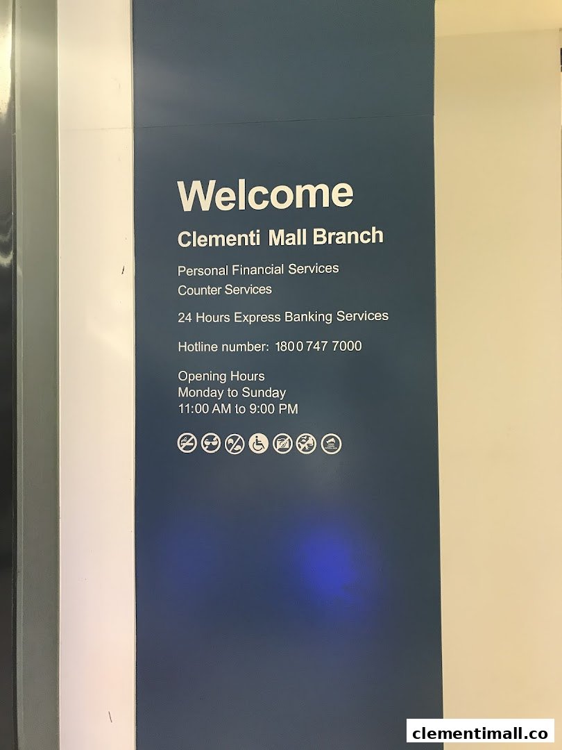 An informational sign for Standard Chartered Bank Clementi Mall Branch detailing services, hotline, and opening hours.