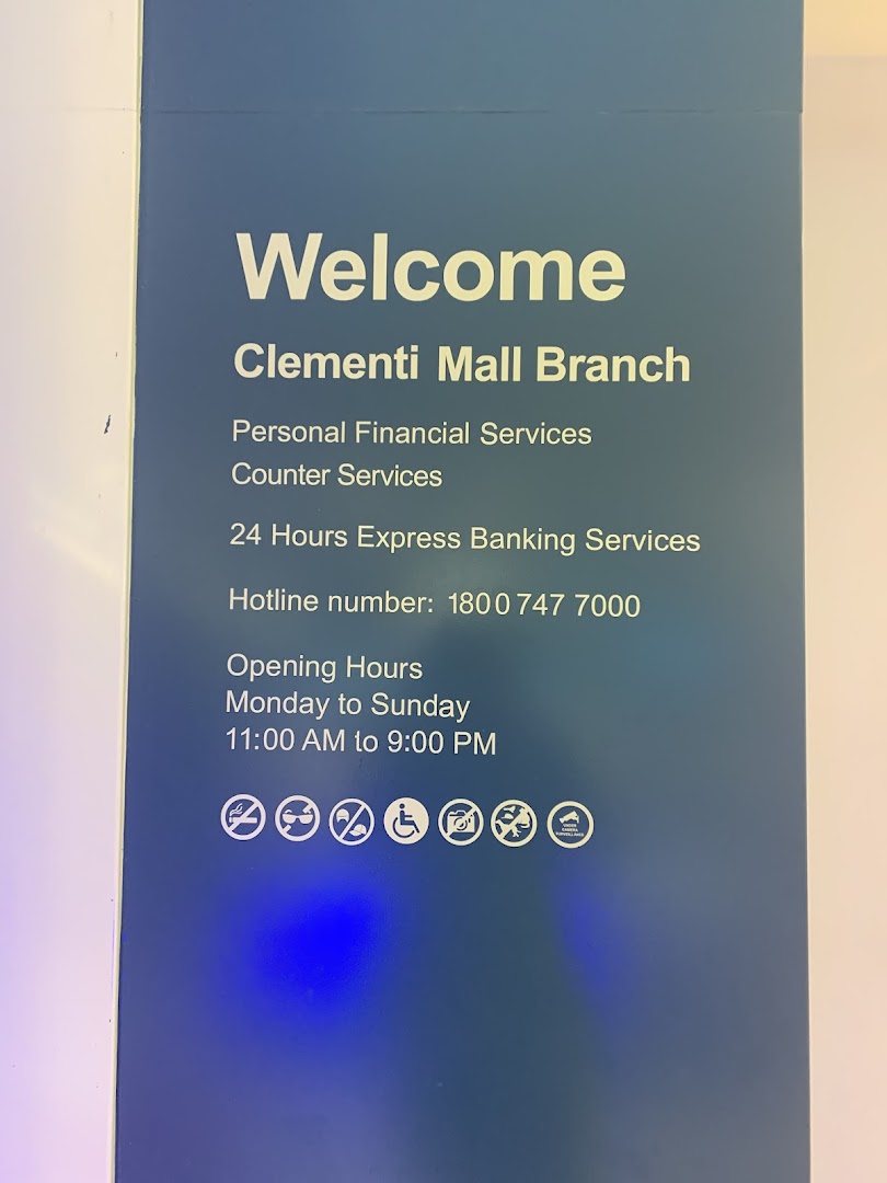 A blue sign displaying services, hotline, and opening hours for Standard Chartered Bank.