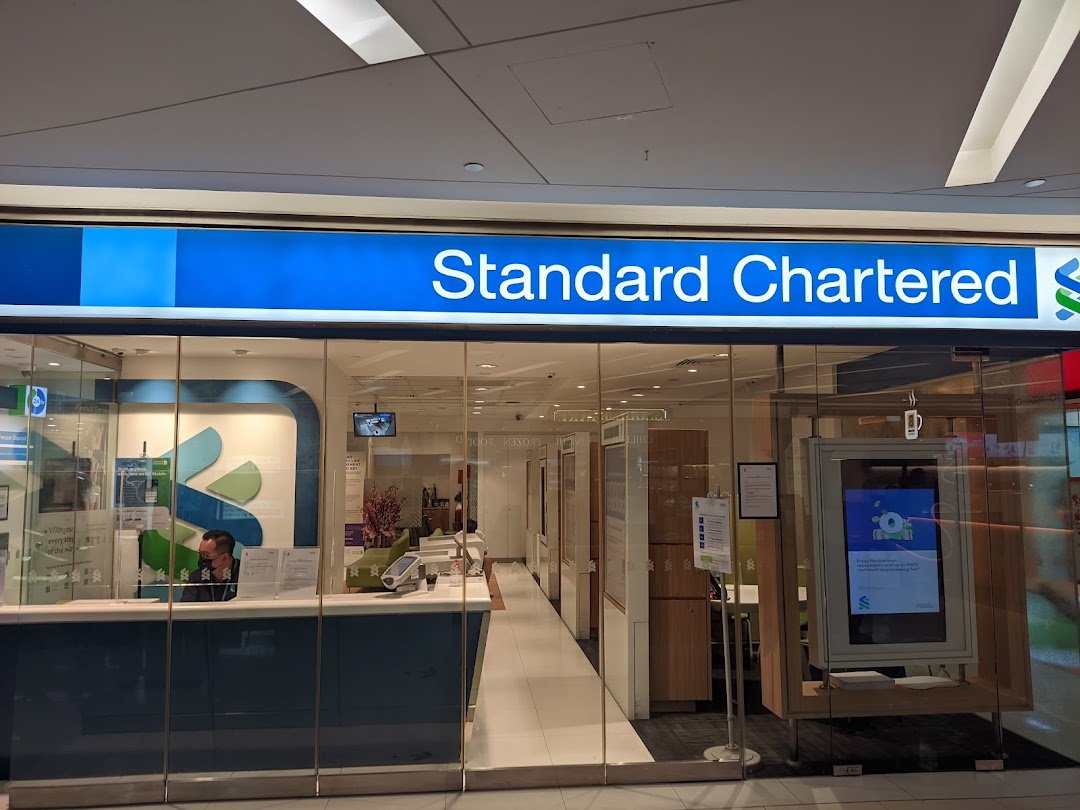The brightly lit entrance of Standard Chartered Bank at The Clementi Mall, featuring its prominent blue signage.